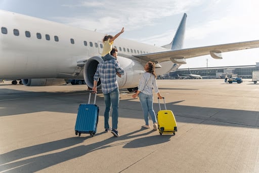 A family prepares to board an airplane for a summer vacation.